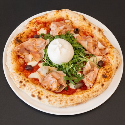 Buratissima — Sauce tomate, burrata, basilic, jambon cru, olives, roquette, origan.