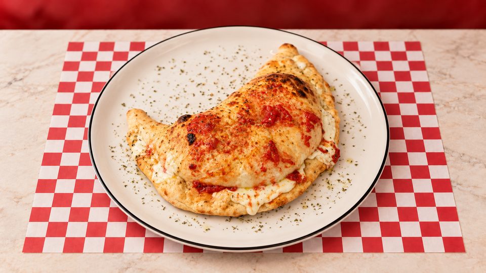 Pizza Calzone Burrata — Sauce pesto, persillade, jambon, burrata, mozzarella fior di latte.