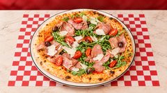 Italiana — Sauce tomate, mozzarella fior di latte, jambon fumé sec, roquette, grana.