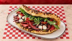 Campione — Stracciatella, crème balsamique, tomates confites, poivrons confits, pastrami, bresaola, roquette, pesto.
