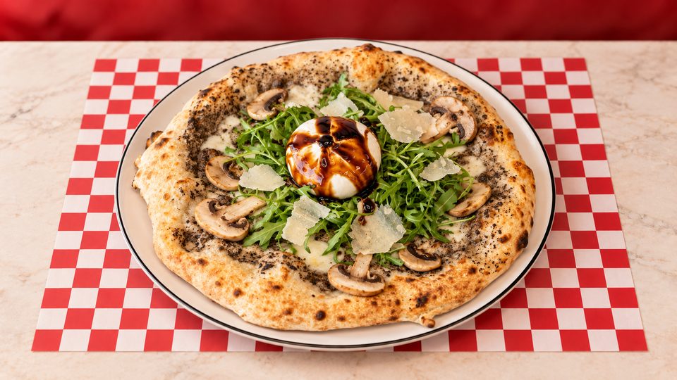 Pizza Al Tartufo — Sauce truffe, mozzarella fior di latte, champignons, roquette, burrata, copeaux de parmesan, crème balsamique.